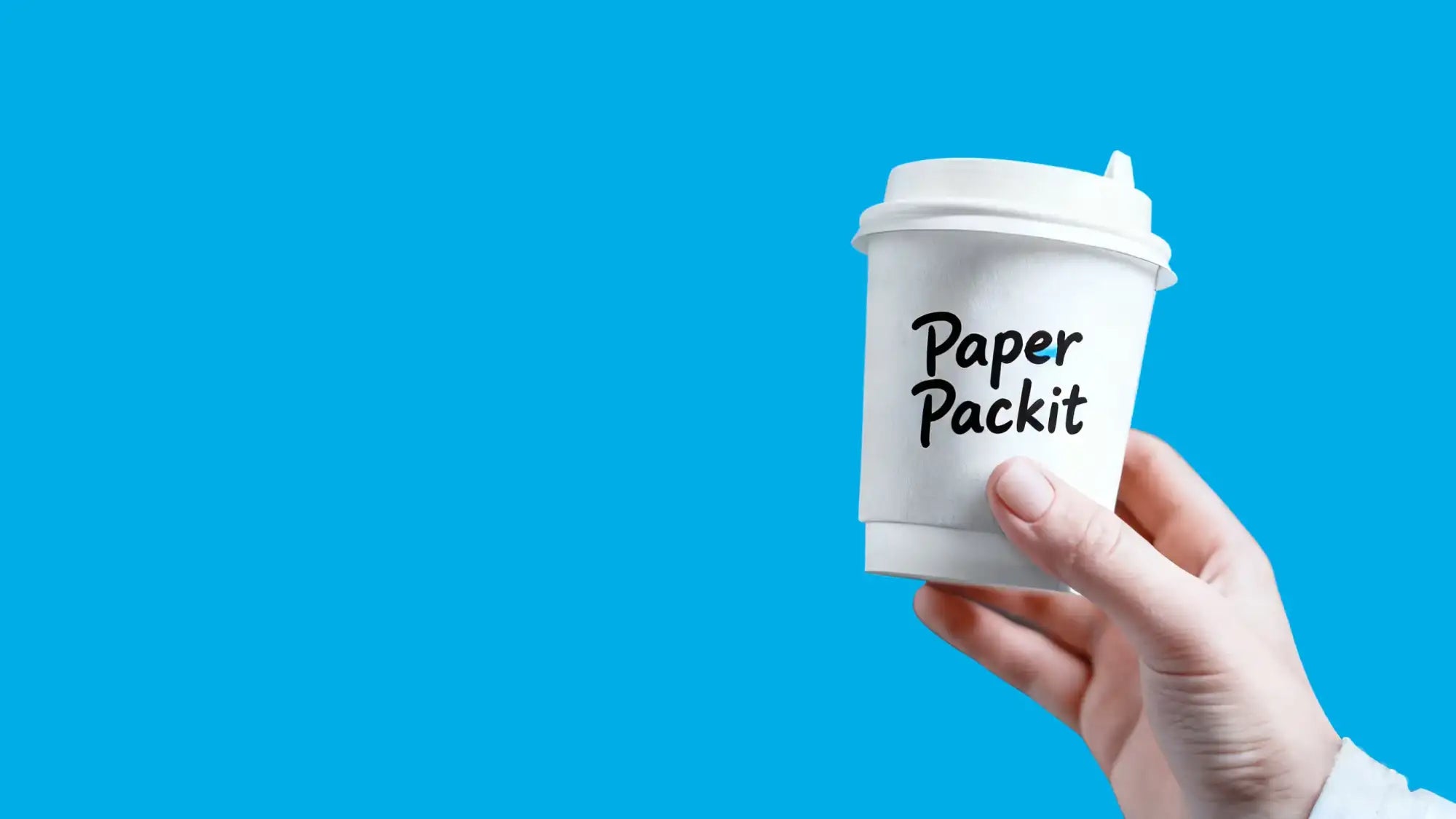 White paper coffee cup with a matching lid, featuring the black text ’paper packit’ printed on its side.